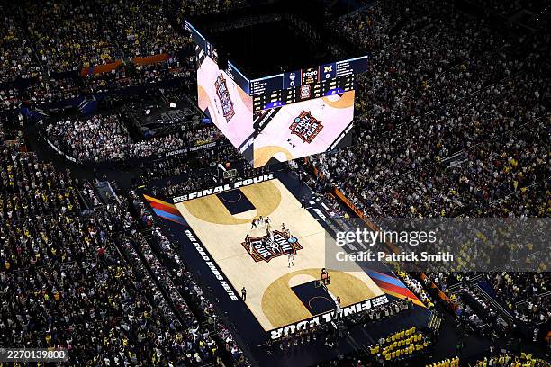 Aday Mara of the Michigan Wolverines and Tarris Reed Jr. #5 of the UConn Huskies take the tip off during the first half of a game in the National...