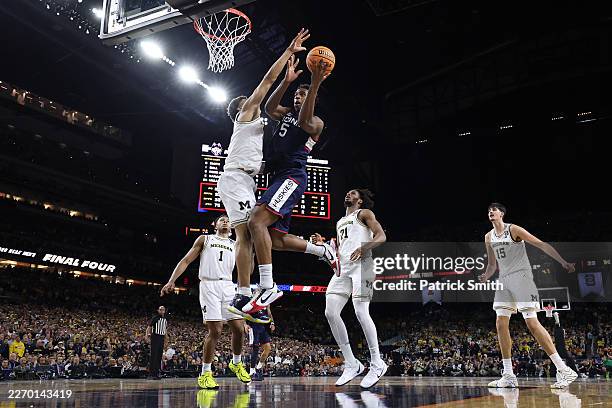 Yaxel Lendeborg of the Michigan Wolverines defends Tarris Reed Jr. #5 of the UConn Huskies during the first half of a game in the National...