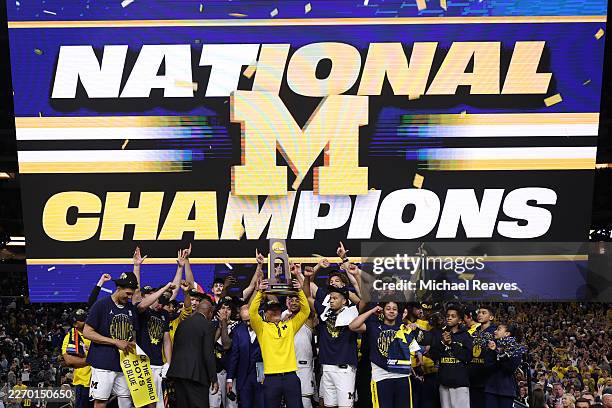 Head coach Dusty May of the Michigan Wolverines hoists the trophy after defeating the UConn Huskies 69-63 in the National Championship of the 2026...