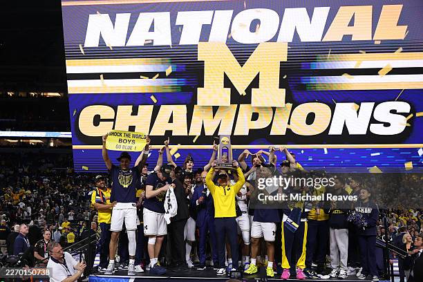 Head coach Dusty May of the Michigan Wolverines hoists the trophy after defeating the UConn Huskies 69-63 in the National Championship of the 2026...