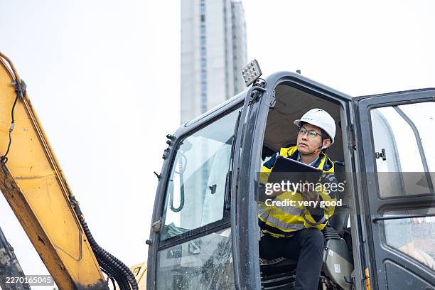 male engineer and tablet working on construction heavy machine background - structural engineer stock pictures, royalty-free photos & images
