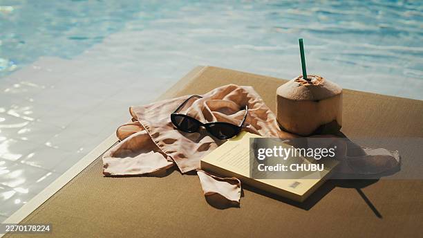 composizione dello stile di vita estivo con acqua di cocco e occhiali da sole a bordo piscina - bordo piscina foto e immagini stock