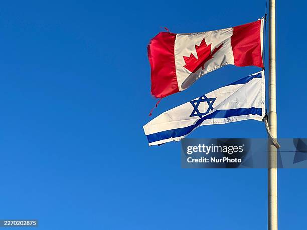 The national flags of Canada and Israel are seen outside a synagogue in Vaughan, Ontario, Canada, on April 9, 2026.