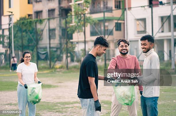 volunteers picking up plastic waste in urban green space - collection stock pictures, royalty-free photos & images