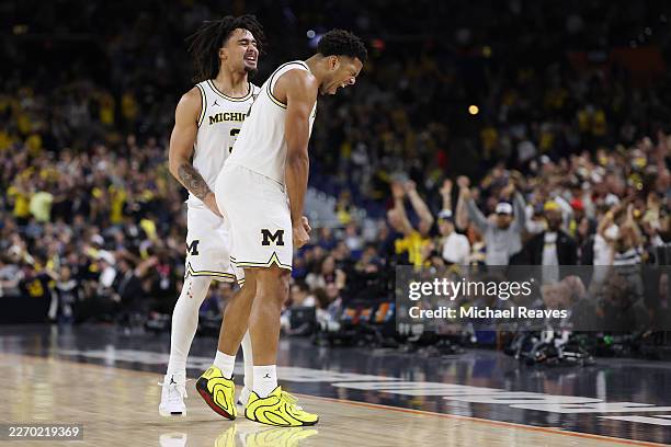 Trey McKenney and Elliot Cadeau of the Michigan Wolverines celebrate a three pointer against the UConn Huskies in the National Championship of the...