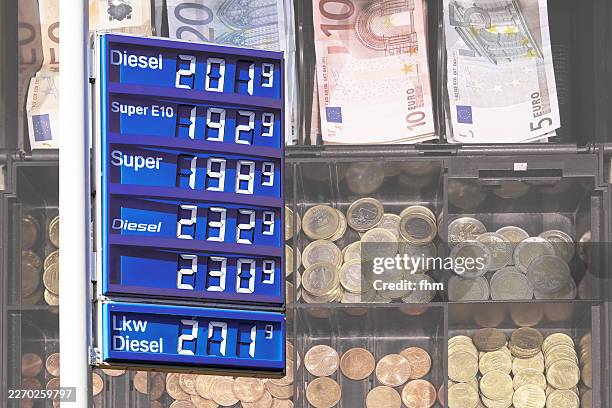 display board at a fuel station with euro money in a cash register in the background - recession stock pictures, royalty-free photos & images