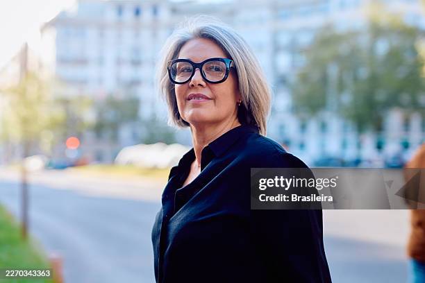 confident mature woman with gray hair smiling outdoors - bobbed hair stock pictures, royalty-free photos & images