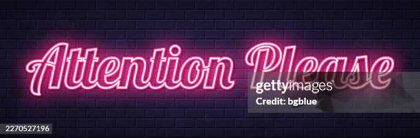 attention please - glowing neon text on brick wall background - attention please stock illustrations
