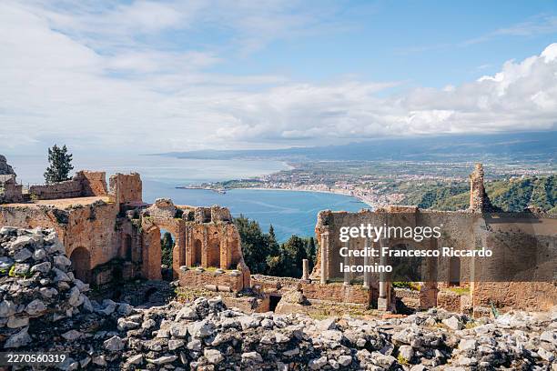 ancient greek theater in taormina, sicily, offers stunning views of the coast and mount etna. - sicily stock pictures, royalty-free photos & images