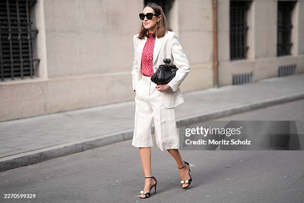 Annette Weber is seen wearing a light beige tailored suit with a relaxed fit, consisting of a single breasted blazer and knee length tailored shorts...