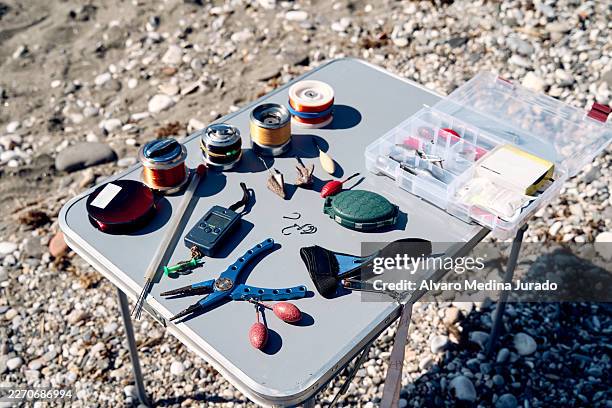 fishing equipment laid out on beach table - fishing tackle stock pictures, royalty-free photos & images