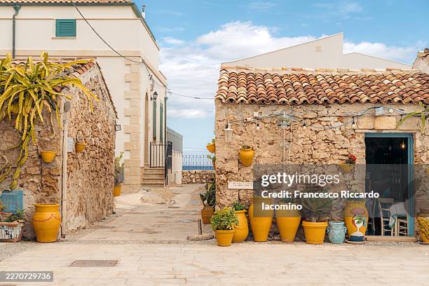 marzamemi sicily street scene with colorful pottery and a restaurant entrance. - sicily stock pictures, royalty-free photos & images