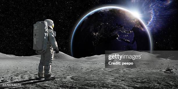 astronaut standing on the moon looking towards sun rise on a distant earth - space exploration stock pictures, royalty-free photos & images