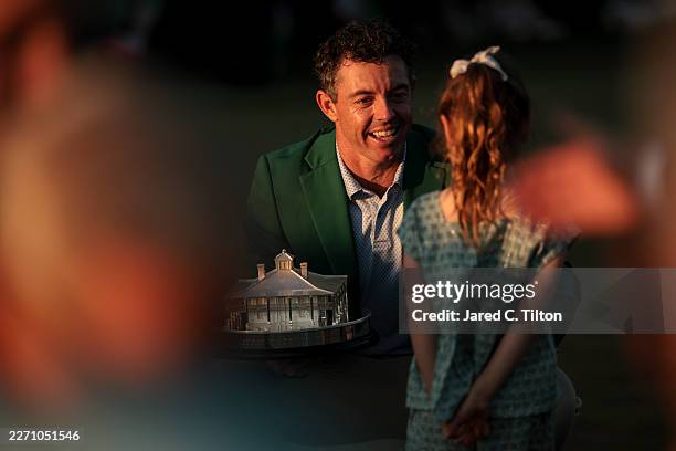 Rory McIlroy of Northern Ireland talks with his daughter Poppy while holding the Masters trophy during the Green Jacket Ceremony after winning during...