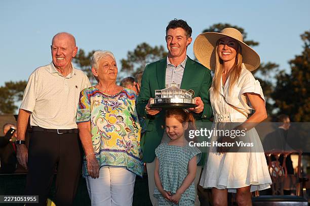 Rory McIlroy of Northern Ireland poses with the Masters trophy during the Green Jacket Ceremony alongside father Gerry , mother Rosie , wife Erica...
