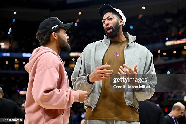 Trae Young listens to Anthony Davis of the Washington Wizards during the fourth quarter against the Cleveland Cavaliers at Rocket Arena on April 12,...