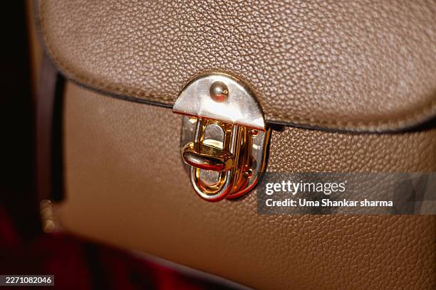 close-up of gold clasp on luxury leather handbag - leather purse stock pictures, royalty-free photos & images