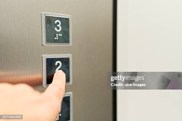 person pressing elevator second floor button for destination - elevator button stock pictures, royalty-free photos & images