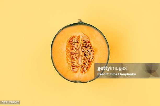 half of ripe cantaloupe melon with seeds on yellow background, fresh summer fruit concept - melon stock pictures, royalty-free photos & images