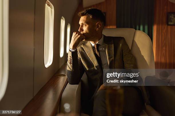 thoughtful businessman relaxing during a flight by a private airplane. - billionaire stock pictures, royalty-free photos & images