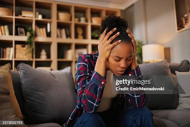 stressed woman experiencing headache or hormone problems at home - post traumatic stress disorder stock pictures, royalty-free photos & images