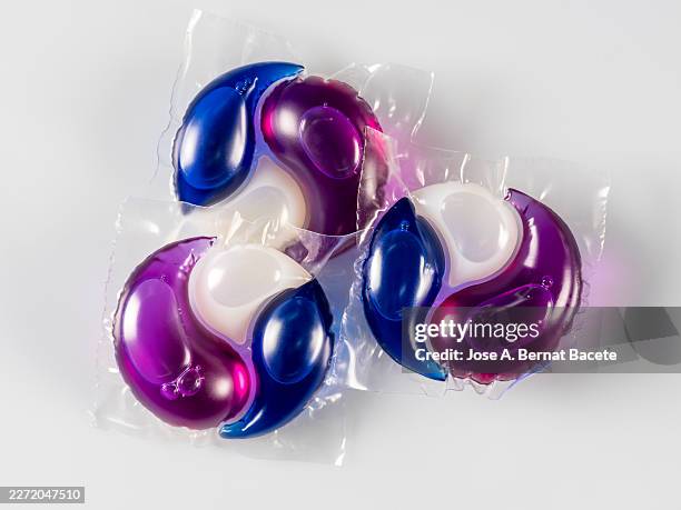 three single-dose washing machine detergent tablet with three products, isolated on white background for design purposes. - detergent pod stock pictures, royalty-free photos & images