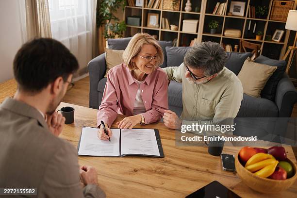 couple âgé signant un contrat d’assurance vie avec un agent - testament photos et images de collection
