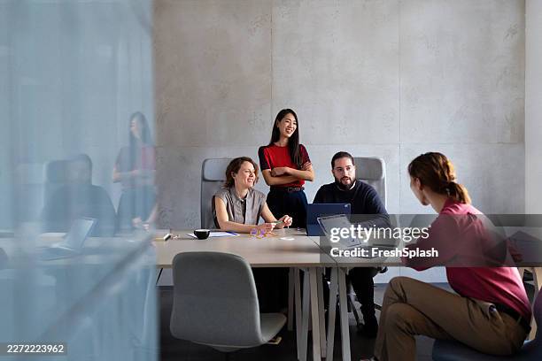 business team collaborating around conference table in office - executive chair stock pictures, royalty-free photos & images