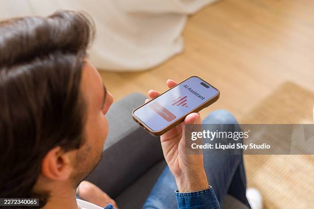 joven usando smartphone con aplicación de asistente de ia - reconocimiento del habla fotografías e imágenes de stock
