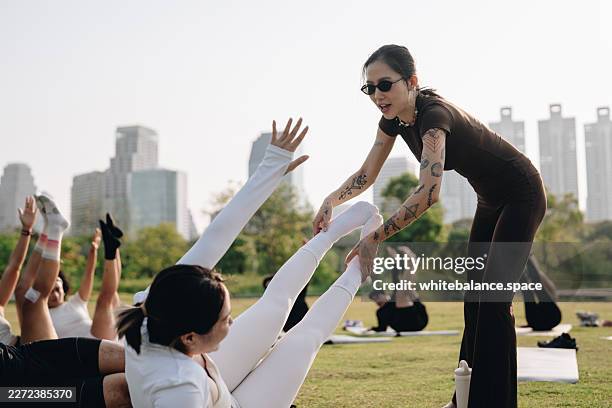 yoga instructor guiding group in park, outdoor fitness, wellness coaching, mindful movement - yoga instructor stock pictures, royalty-free photos & images