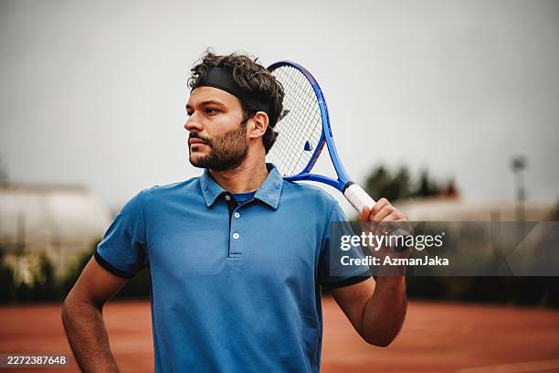 young indian tennis player posing with racket on clay court on overcast day - headband stock pictures, royalty-free photos & images