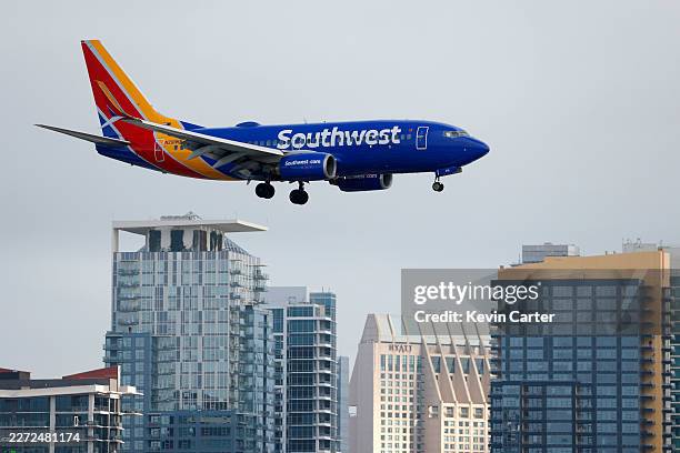Southwest Airlines Boeing 737 airplane approaches San Diego International Airport for a landing arriving from Sacramento with downtown high rises in...