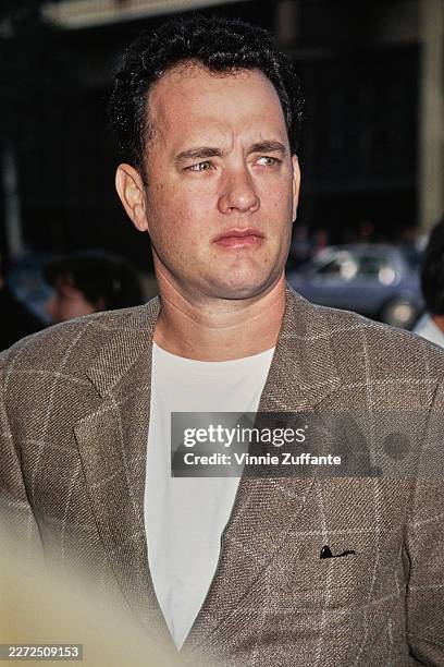 American actor Tom Hanks, wearing a checked brown blazer over a white t-shirt, attends the Hollywood premiere of 'Toy Story' at the El Capitan...