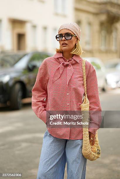 Julia Kammerer is seen wearing a red and white gingham button down blouse from Pull&Bear; light blue pinstripe wide leg trousers from JJXX; a beige...