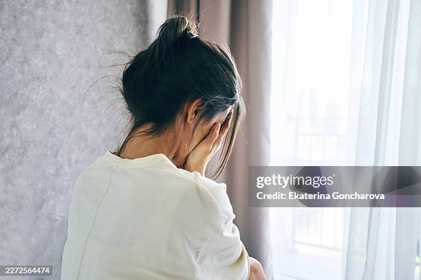 woman hiding face crying feeling sadness and despair - head in hands stock pictures, royalty-free photos & images