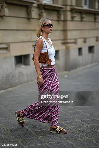 Julia Kammerer is seen wearing a white cotton sleeveless tank top with a ribbed v neckline from Zara; a pink, purple and white horizontal striped...