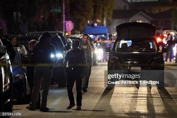 Agents are seen behind police tape near a residence associated with the alleged White House Correspondents' Dinner shooter in Torrance, California,...