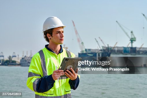 Engineer using tablet checking operations at shipyard Engineer using tablet checking operations at shipyard
