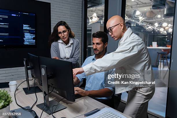 software development team collaborating at computer during coding project discussion. - devops stock pictures, royalty-free photos & images