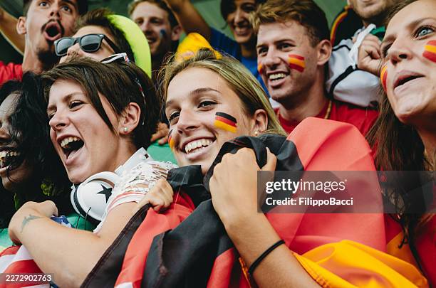 deutsche und vielfältige fußballfans jubeln im stadion - fußball wm stock-fotos und bilder