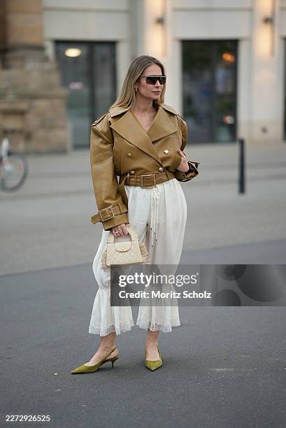 Iryna Thater is seen wearing a mustard yellow lambskin jacket with a double breasted golden button front closure, wide lapels, epaulettes and a...