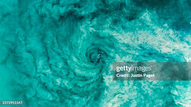 an overhead aerial/drone view onto a tornado rip current in the sea off the coast of western australia - flowing water stock pictures, royalty-free photos & images