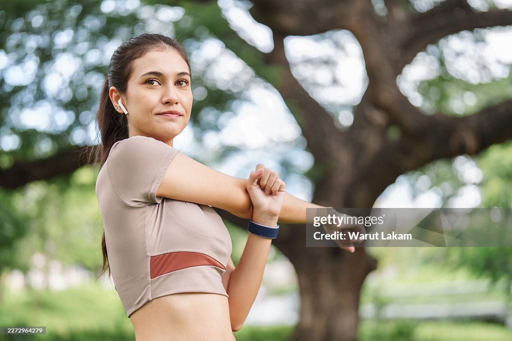 Woman Performs Arm Stretch Public Park Wellness Routine