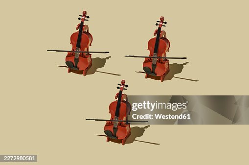 Three handcrafted cellos arranged in rhythmic minimalist pattern with shadow Three handcrafted cellos arranged in rhythmic minimalist pattern with shadow