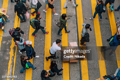Menschenmenge überquert die Straße am Fußgängerüberweg in Hongkong Menschenmenge überquert die Straße am Fußgängerüberweg in Hongkong