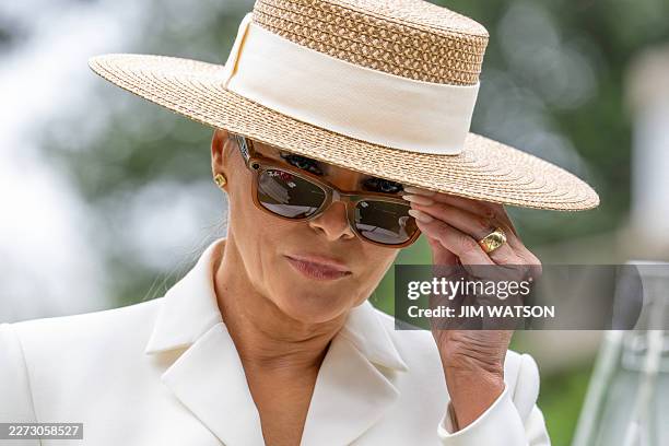 First Lady Melania Trump tries on Meta RayBan glasses during a youth activity with Britain's Queen Camilla on the White House tennis court area in...