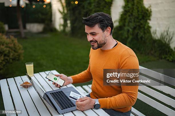 man making an online purchase with smartphone and credit card - electric skateboard stock pictures, royalty-free photos & images