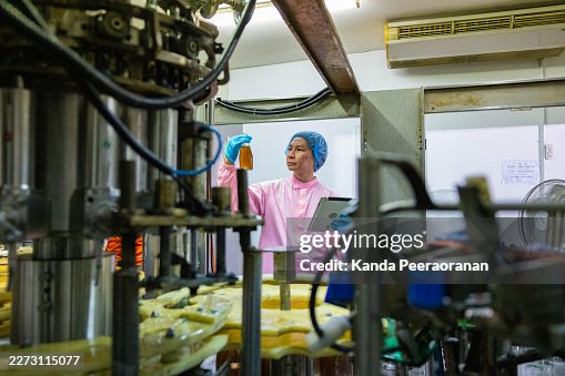 Quality Control Worker Inspecting Liquid Sample in Factory Quality Control Worker Inspecting Liquid Sample in Factory