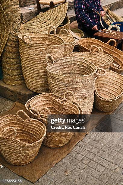artisan weaving straw baskets at street market - wicker stock pictures, royalty-free photos & images