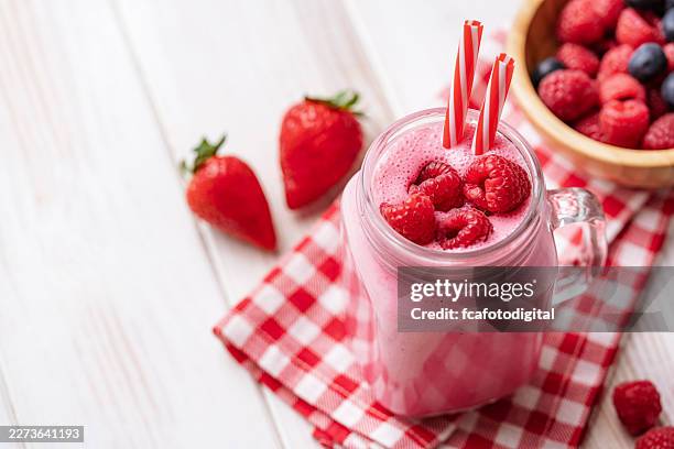raspberry smoothie shot from above on white table. fresh and homemade fruits drink - raspberry cocktail stock pictures, royalty-free photos & images